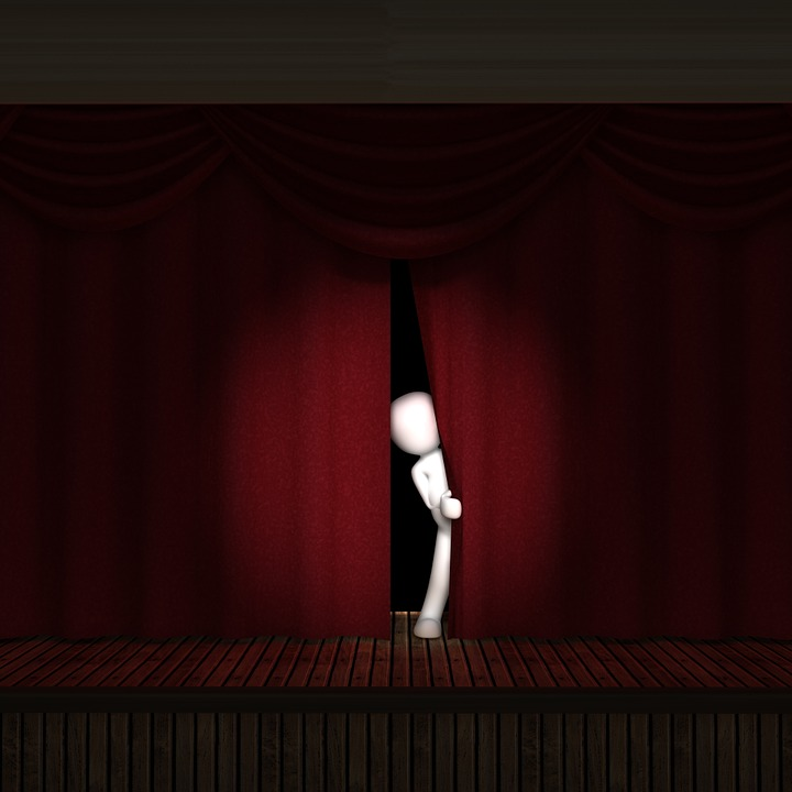 A person with stage fright peeking out from behind a curtain